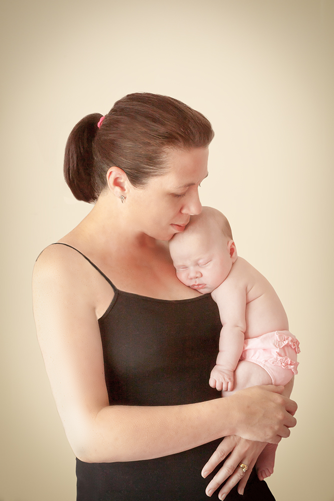 Close portrait of an adult holding a baby against the shoulder, ideal for showcasing professional photo restoration services for intimate family moments.