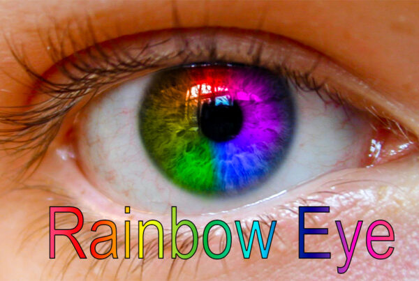 A wide panoramic banner showing a high-detail macro shot of a human eye where the iris has been transformed into a vibrant, seamless rainbow gradient using Photoshop blending modes, with text "Rainbow Eye" at the bottom.