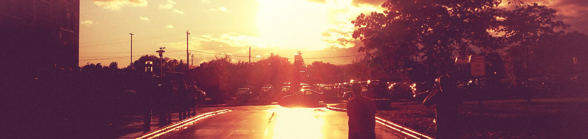 A wide panoramic banner showing a modern portrait being transformed with soft, colorful light leaks—ranging from warm oranges to cool purples—bleeding in from the edges.