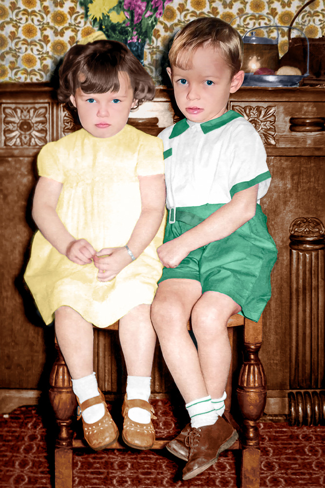 Restored colour portrait of two children sitting together, demonstrating the results of professional photo restoration services.