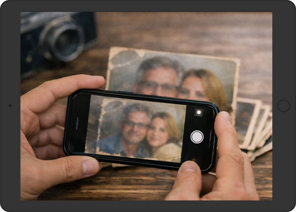 Person using a smartphone to photograph an old printed photo, demonstrating how to get the best quality photos for editing when a scanner isn’t available.